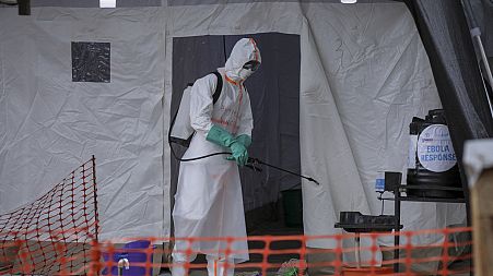 A medical worker disinfects a tent used for suspected Ebola victims inside the isolation center of Madudu Health Center III, Tuesday, Nov. 1, 2022.
