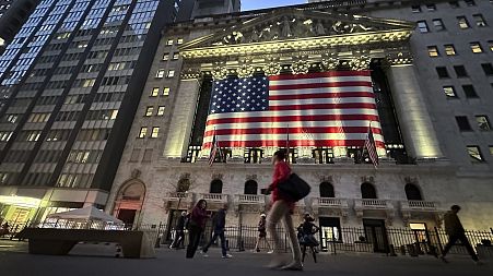 People pass the New York Stock Exchange in New York.