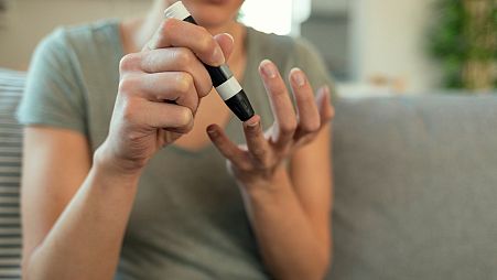 A woman checks her blood sugar levels.